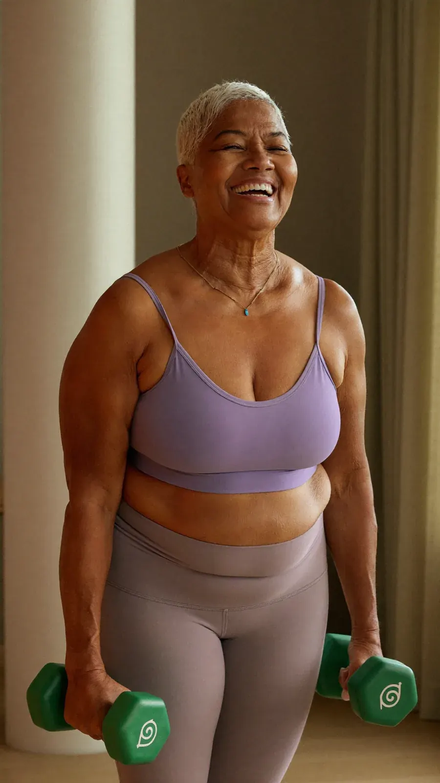 Woman in her seventies laughing while lifting dumbbells