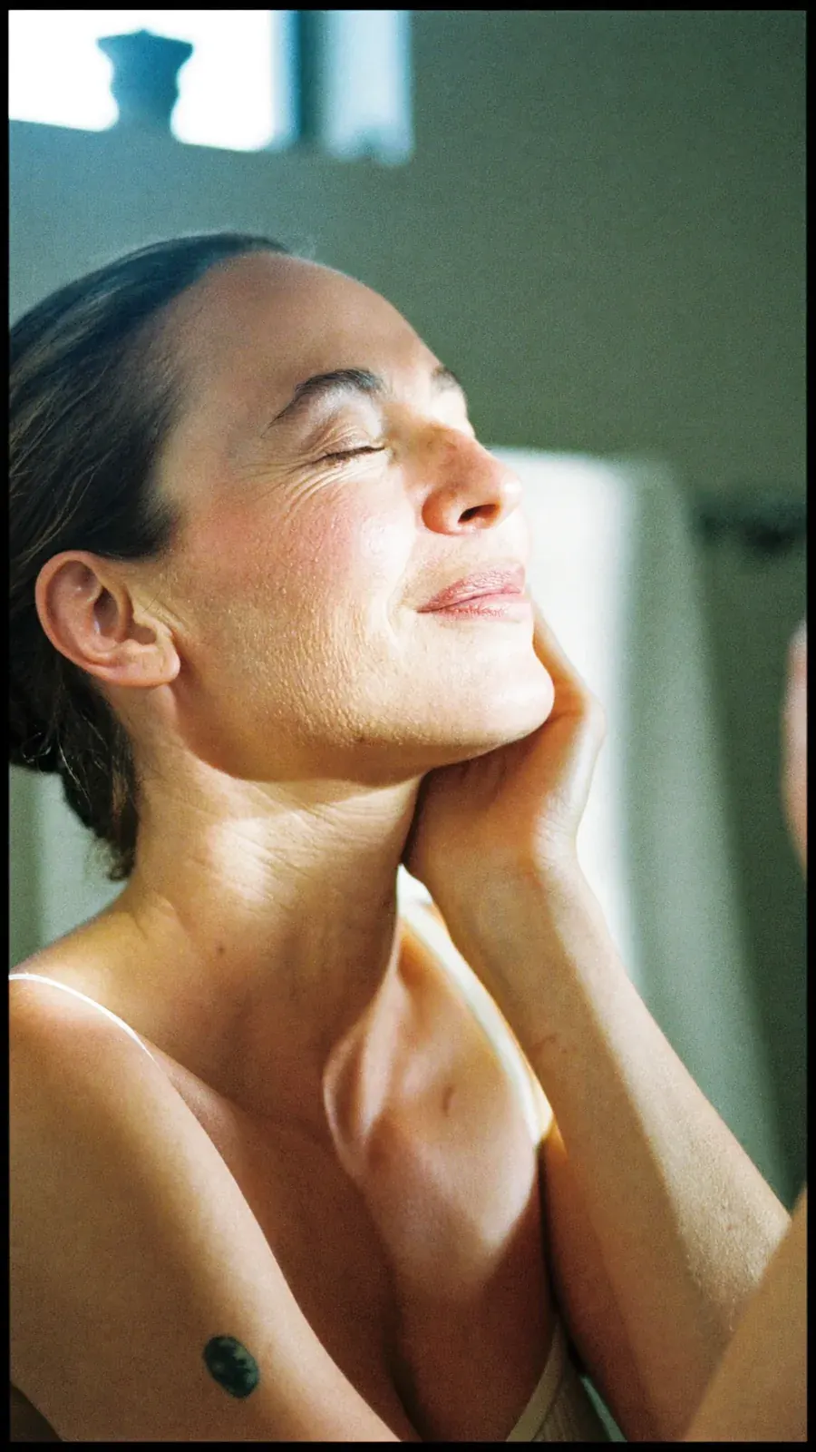 Sunlit woman with eyes closed